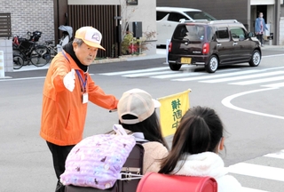 スクールガードとして活動している村田良和さん（左）。子どもの安全のため、毎朝交差点に立つ＝明石市大久保町ゆりのき通１