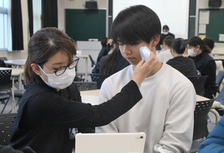 肌質を測定される学生（右）＝明石高専