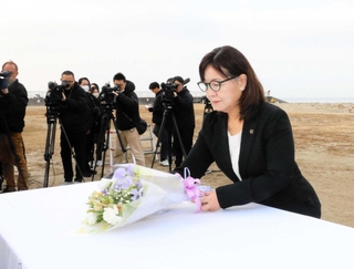 献花台に花を手向ける丸谷聡子市長＝大蔵海岸