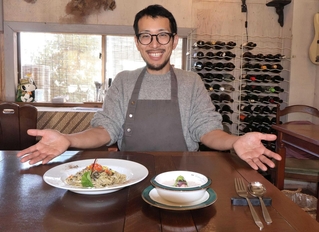 「江井島の海を表現した」というスープやパスタを前に笑顔の足立洋平さん＝明石市大久保町江井島