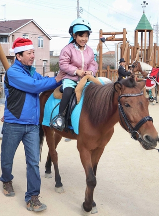 昨年末に開かれたこども園のクリスマス会で、乗馬を体験する園児＝明石市大久保町大久保町
