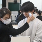 肌質を測定される学生（右）＝明石高専