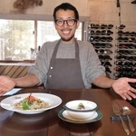 「江井島の海を表現した」というスープやパスタを前に笑顔の足立洋平さん＝明石市大久保町江井島