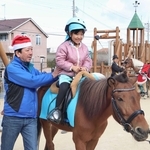 昨年末に開かれたこども園のクリスマス会で、乗馬を体験する園児＝明石市大久保町大久保町