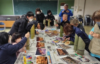 竹灯籠に文字を書く福石健一さんと住民ら（福石健一さん提供）＝２０２５年１２月、宮城県気仙沼市