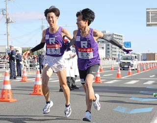３度目の箱根駅伝で力強く走り出す立教大４区の国安広人主将（右）＝１月２日、平塚中継所