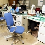 過去の訓練で机の下に潜る職員たち＝明石市役所