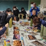 竹灯籠に文字を書く福石健一さんと住民ら（福石健一さん提供）＝２０２５年１２月、宮城県気仙沼市