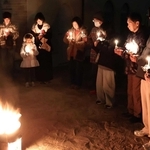 ろうそくを手に黙とうする人たち＝明石市東仲ノ町