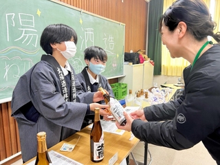 児童らが企画した「江井島特産品展」で地元の酒をＰＲする児童ら＝明石市大久保町西島