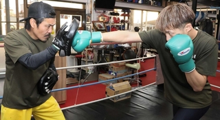 三宅尚輝さん（右）のパンチをミットで受ける戎岡彰会長＝明石市魚住町住吉２