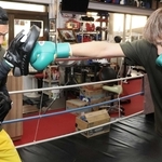 三宅尚輝さん（右）のパンチをミットで受ける戎岡彰会長＝明石市魚住町住吉２