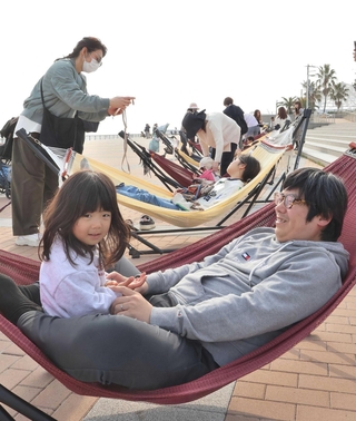 展望エリアのハンモックカフェでくつろぐ親子＝明石市中崎１