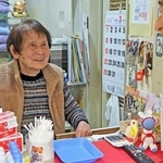 番台で客と談笑する岡本智恵子さん＝明石市大蔵天神町