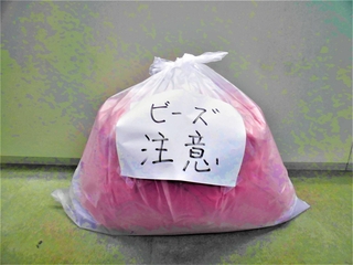 明石市が呼びかけるマイクロビーズ入りのクッションをごみ出しする方法。袋を二重にし、張り紙を付ける（同市提供）