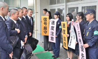 登校してきた生徒に自転車の安全運転を呼びかける生徒会役員や明石署員ら＝明石商業高校