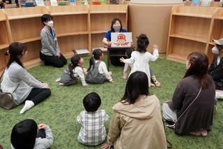 読み聞かせを楽しむ親子ら＝明石市二見町西二見駅前１