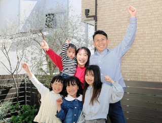 出発に向けて意気込む柏木優作さん（上段右）と妻春香さん（同右から２人目）ら家族＝明石市内