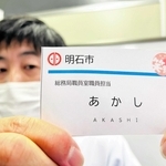 カスハラ対策の一環として明石市が導入した新たな職員の名札。顔写真と名字の漢字表記を削除している＝明石市役所