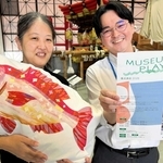 ミュージアムプレーヤー養成講座への参加を呼びかける明石市立文化博物館の武井二葉館長（左）ら。活動の一環で魚のクッションも作られた＝明石市上ノ丸２