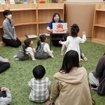 読み聞かせを楽しむ親子ら＝明石市二見町西二見駅前１