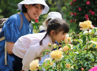 花の香りを嗅ぐ子ども＝県立明石公園
