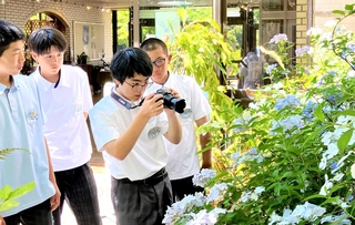 見頃を迎えたアジサイの撮影に挑戦する中学生ら＝花と緑のまちづくりセンター