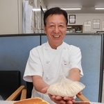 酒かすを使った食パンを前に、酒かすパウダーを手にする中市雅章さん＝明石市硯町３