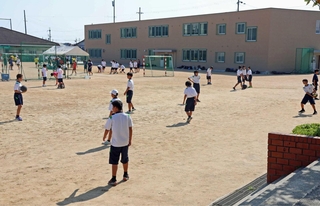 部活動中の生徒たち。奥に見えるのがプレハブ校舎＝大久保北中学校