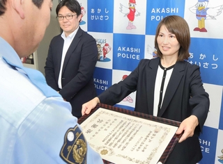 足立雅樹署長から感謝状を受け取る三井住友信託銀行明石支店の吉田照子さん＝明石署