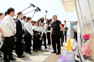 事故現場の歩道橋で、職員に当時の状況や思いを語る下村誠治さん（右）＝明石市大蔵海岸通１