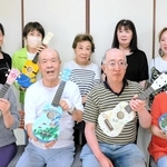さまざまなデザインのウクレレ作りに取り組む利用者と、相川利江子代表（前列左）らスタッフ＝明石市貴崎５