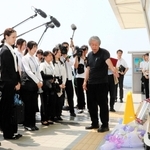 事故現場の歩道橋で、職員に当時の状況や思いを語る下村誠治さん（右）＝明石市大蔵海岸通１