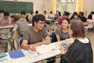 少人数のグループに分かれ、支援者から熱心に日本語を学ぶ生徒ら＝明石市西明石南町１