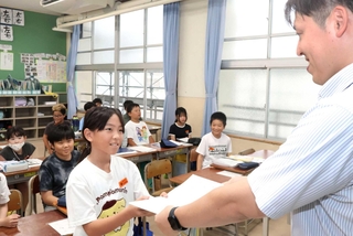 担任の先生に宿題を提出する児童＝鳥羽小学校