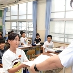担任の先生に宿題を提出する児童＝鳥羽小学校