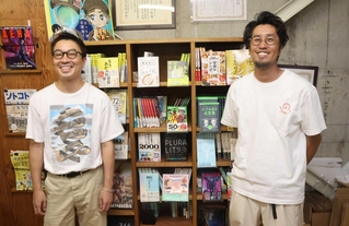 高野翔さん（左）と大塚啓志郎さん。オフィスの本棚には、これまで世に出した本が並ぶ＝明石市桜町