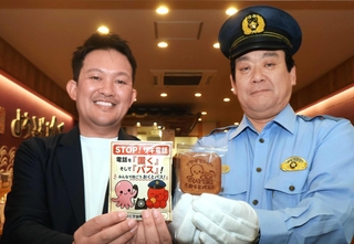 ぱっすーの玉子せんべいを手にする足立雅樹署長（右）と永楽堂の永井健太副社長＝明石市本町１