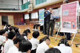 ため池の防災について児童らに話をする西島水利組合の橘忠彦組合長ら＝江井島小学校