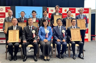 みなと銀行の融資商品を利用し、明石市に寄付した企業の幹部ら＝明石市大明石町１
