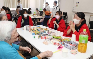 高齢者と交流する明石商業高校福祉科の生徒ら＝明石市魚住町長坂寺