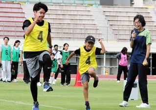小鴨由水さん（右端）から親子で走り方を学ぶ参加者＝きしろスタジアム