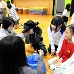 高校生から携帯トイレの使い方を学ぶ児童たち＝魚住小学校