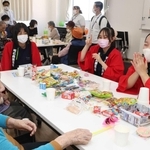 高齢者と交流する明石商業高校福祉科の生徒ら＝明石市魚住町長坂寺