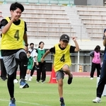 小鴨由水さん（右端）から親子で走り方を学ぶ参加者＝きしろスタジアム