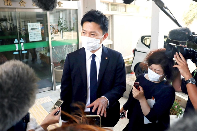 尼崎市議会前で報道陣の取材を受ける光本圭祐尼崎市議＝２０２２年６月２８日