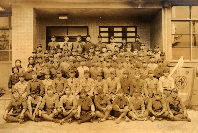 尼崎精工内の生産競争で優勝し、勤務する第二工場前で記念撮影に納まる聴覚障害者の工員ら（１９４３年４月１２日撮影、いずれも尼崎市立地域研究史料館提供）