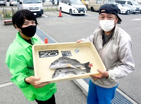 釣りたての魚を武庫川渡船の従業員（左）に手渡す釣り客＝いずれも４月、尼崎市