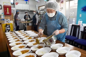 武庫川渡船が提供したチヌ（クロダイ）が入ったカレーを皿に盛り付ける西ユミ子さん