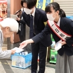 尼崎税務署の一日税務署長を務め、通行人に啓発用のマスクを手渡す川西凛子さん＝尼崎市昭和通３、中央商店街